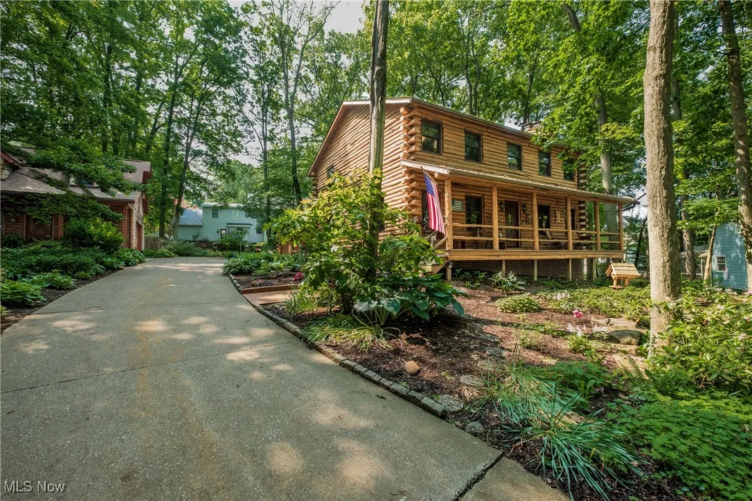 Log cabin featuring log siding and covered porch