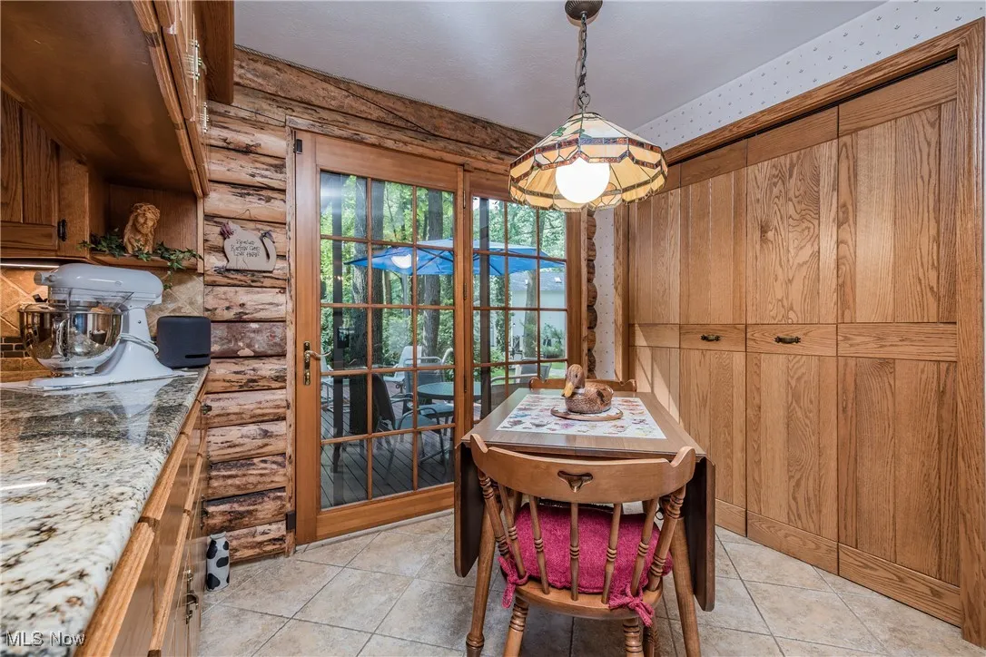 Dining room with light tile patterned flooring and rustic walls