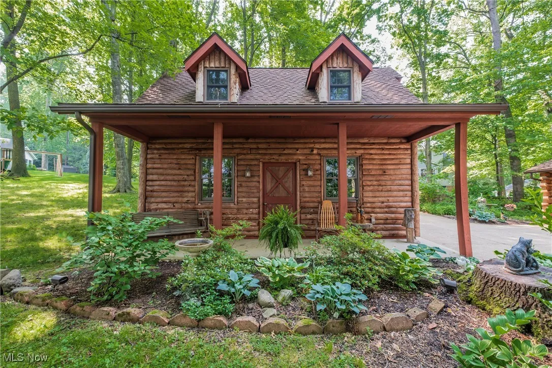 View of front of house featuring a shingled roof and a front lawn