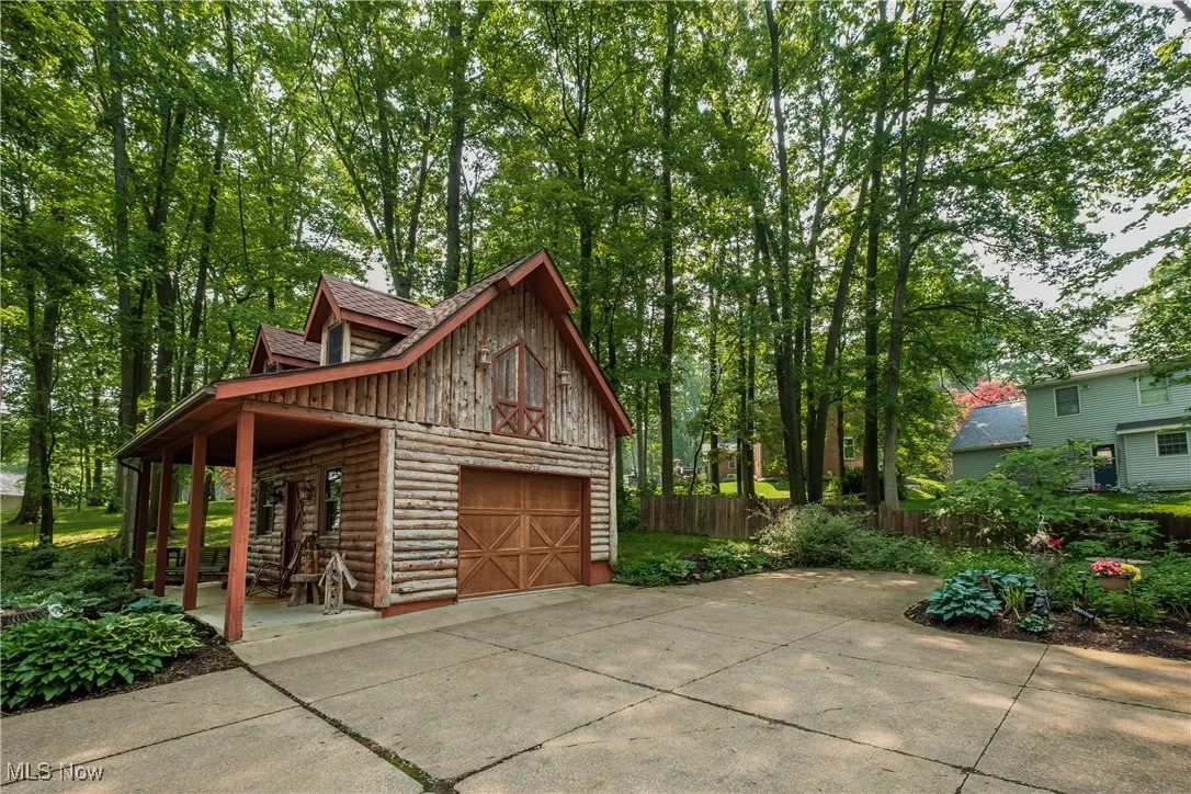 Garage featuring a garage, concrete driveway, and a porch