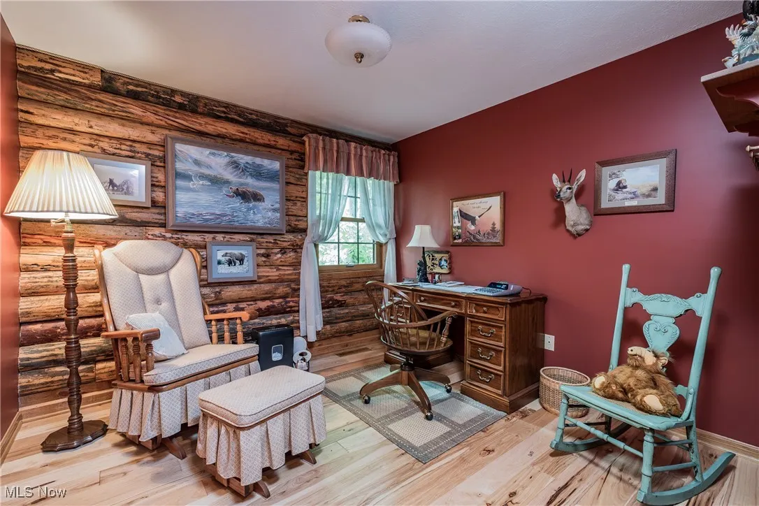 Home office with wood finished floors, rustic walls, and baseboards