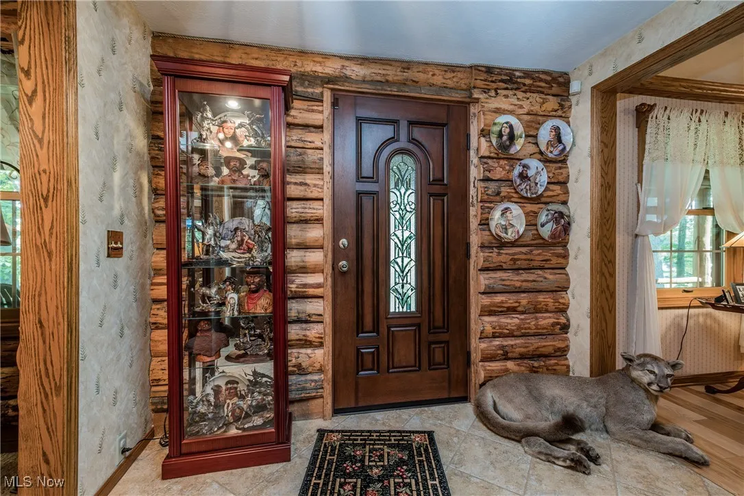 Foyer with rustic walls and wallpapered walls