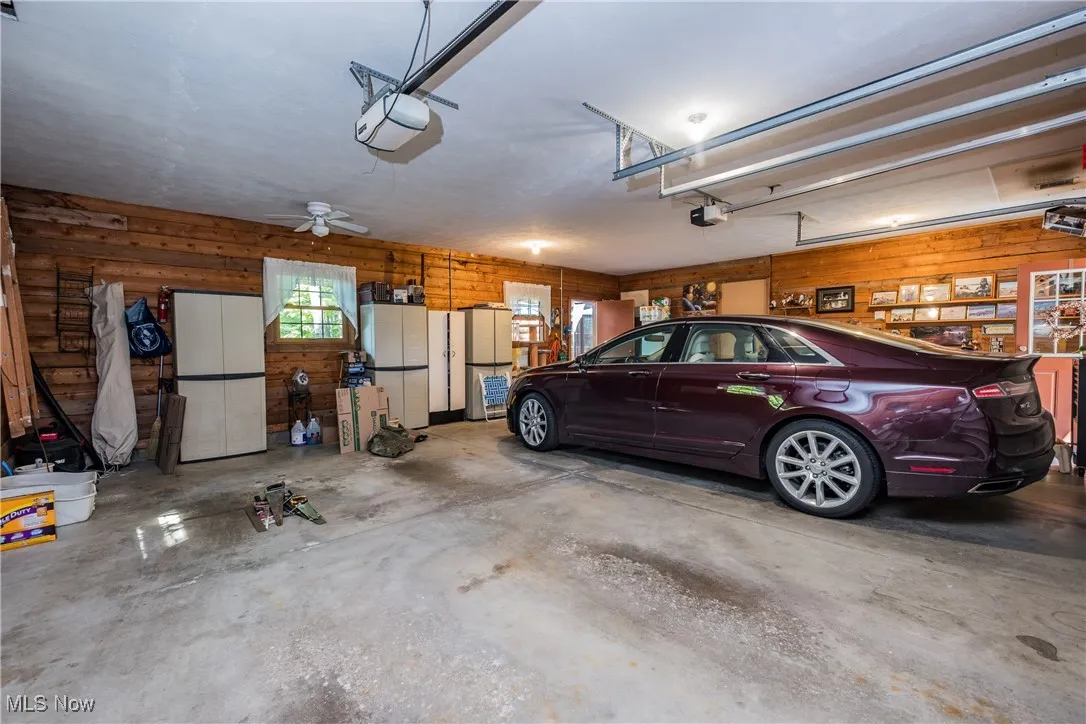 Garage featuring a garage door opener and wooden walls