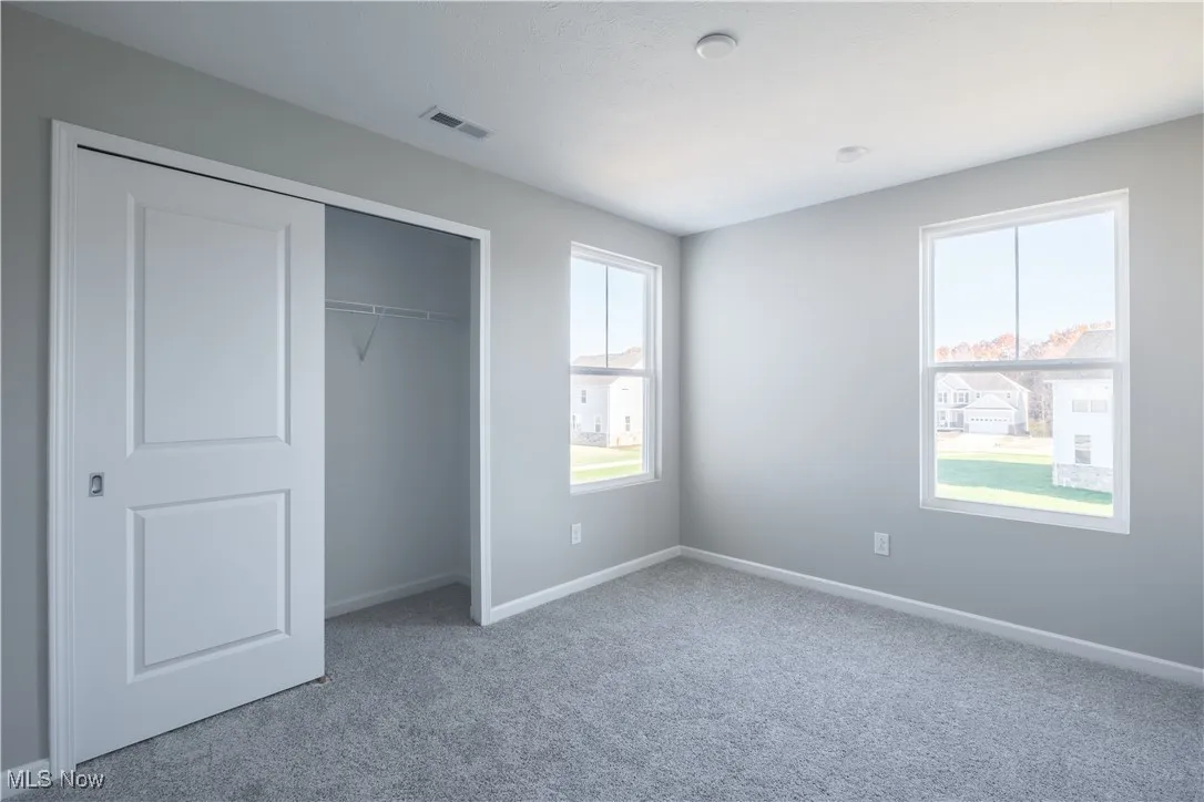 Unfurnished bedroom with carpet and a closet