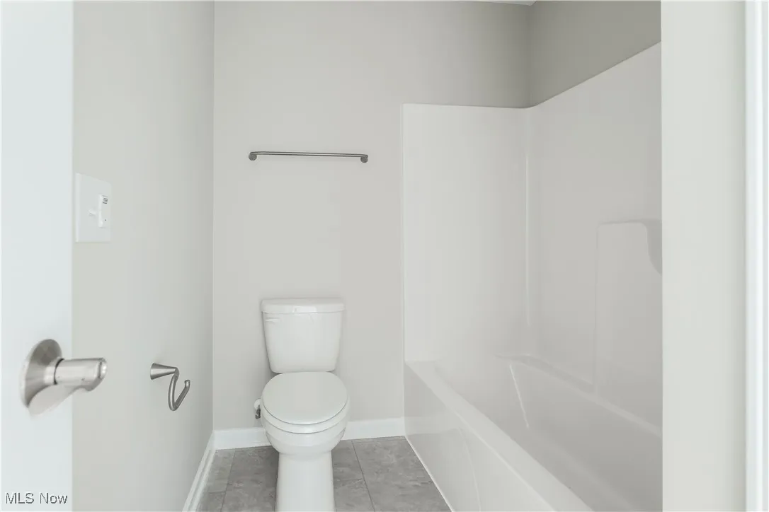 Bathroom with tile patterned floors and bathtub / shower combination