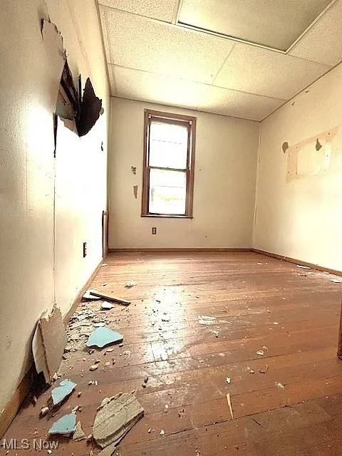 Spare room featuring a drop ceiling and baseboards