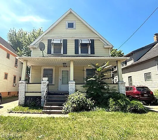 View of front of property featuring covered porch and a front yard