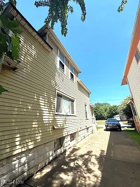 View of side of home featuring concrete driveway