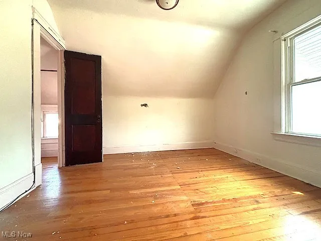 Bonus room featuring healthy amount of natural light, wood-type flooring, and lofted ceiling