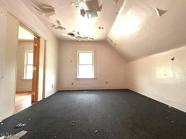 Bonus room featuring vaulted ceiling and baseboards