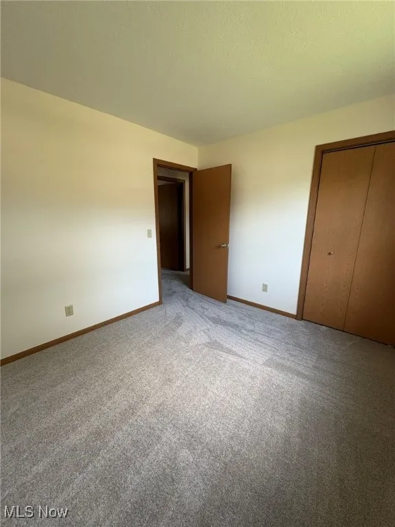 Unfurnished bedroom with carpet flooring and a closet
