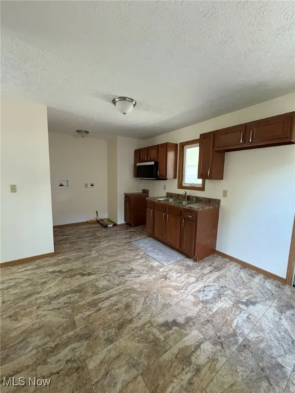 Kitchen featuring a textured ceiling and dark countertops