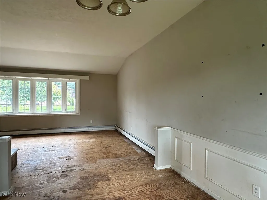 Spare room with vaulted ceiling and a baseboard radiator