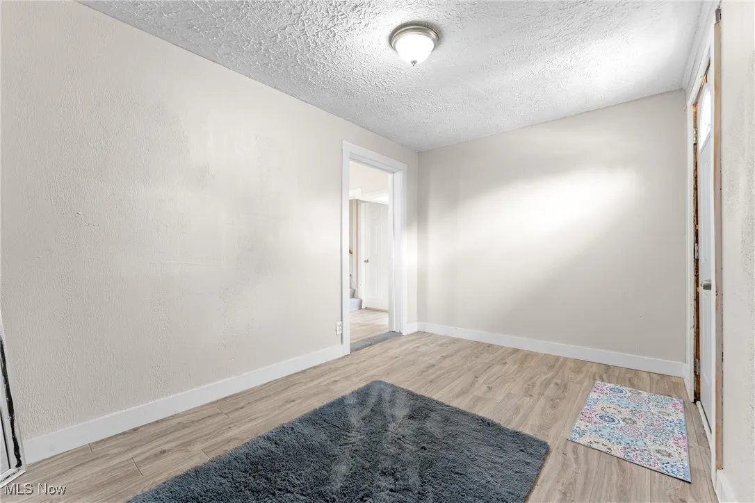 Unfurnished room featuring a textured ceiling and wood finished floors