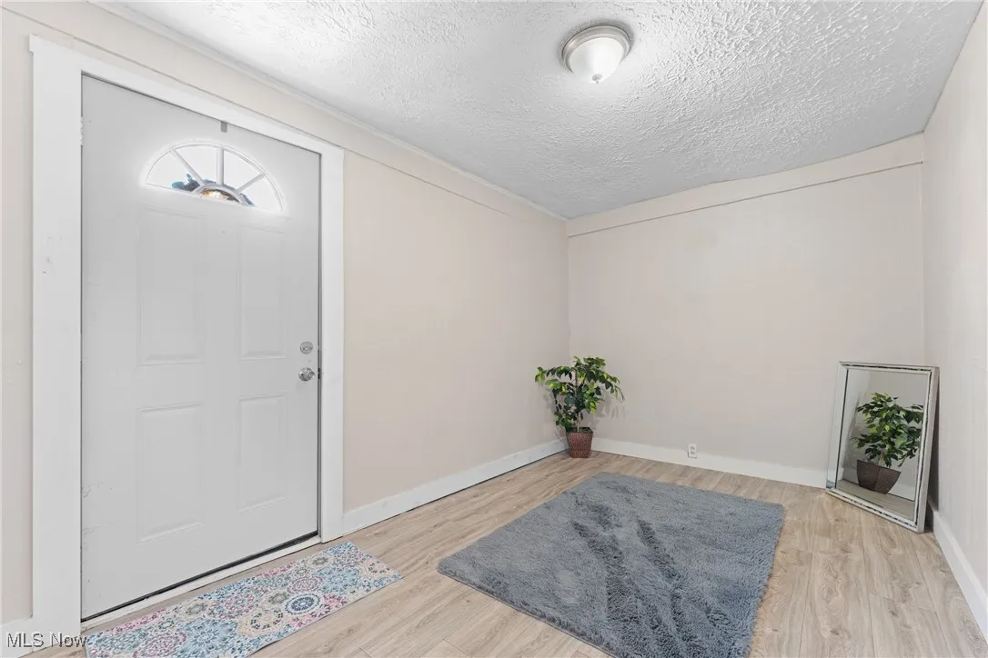 Entryway with a textured ceiling and wood finished floors