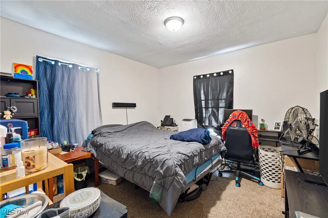 Bedroom with a textured ceiling and carpet floors