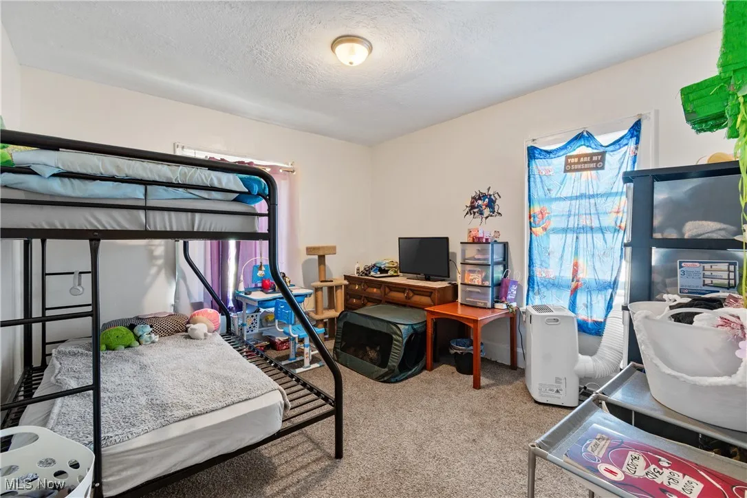 Bedroom with carpet and a textured ceiling