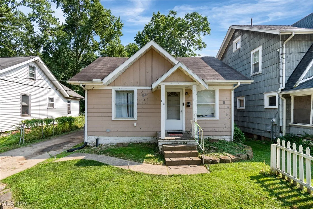 Bungalow-style house featuring roof with shingles, board and batten siding, and driveway