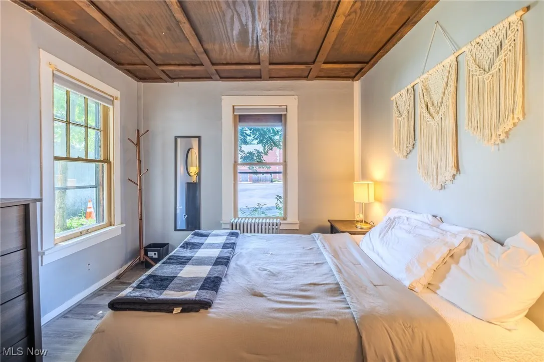 Bedroom with wood finished floors, a wooden ceiling with exposed beams, and coffered ceiling