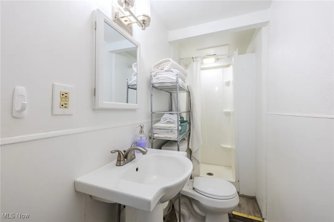 Full bath featuring a stall shower and wood finished floors
