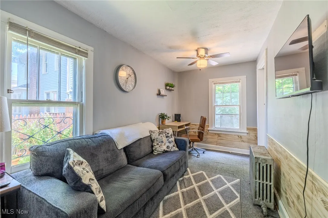 Living room featuring ceiling fan and radiator