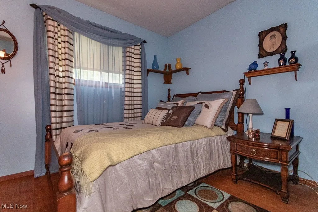 Bedroom with wood finished floors and vaulted ceiling