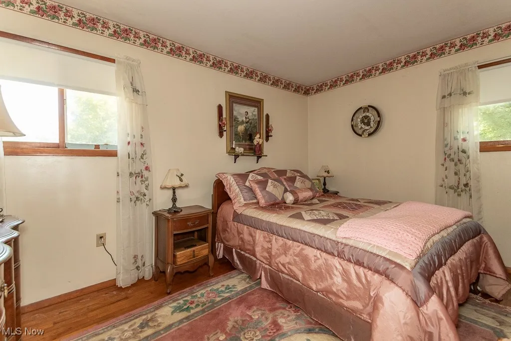 Bedroom with wood finished floors and baseboards