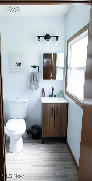 Half bathroom featuring vanity and wood finished floors