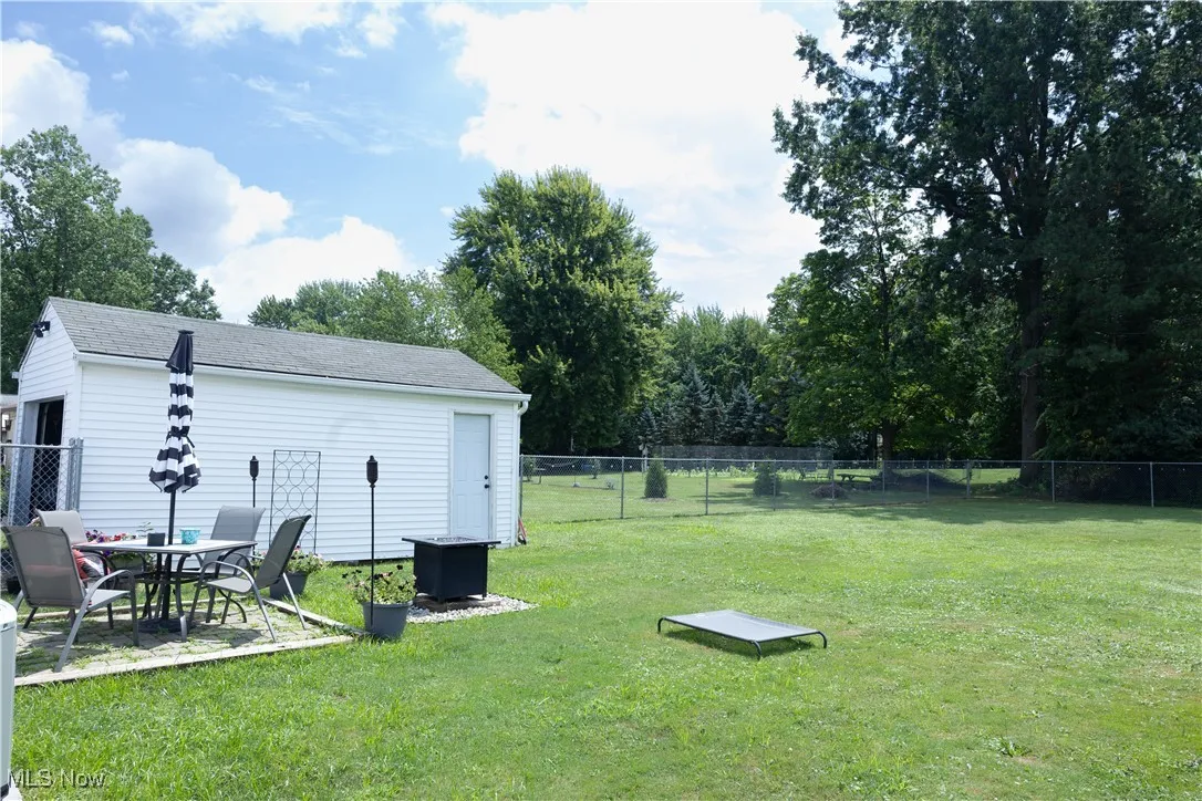 Fenced backyard with a patio and view of wooded area