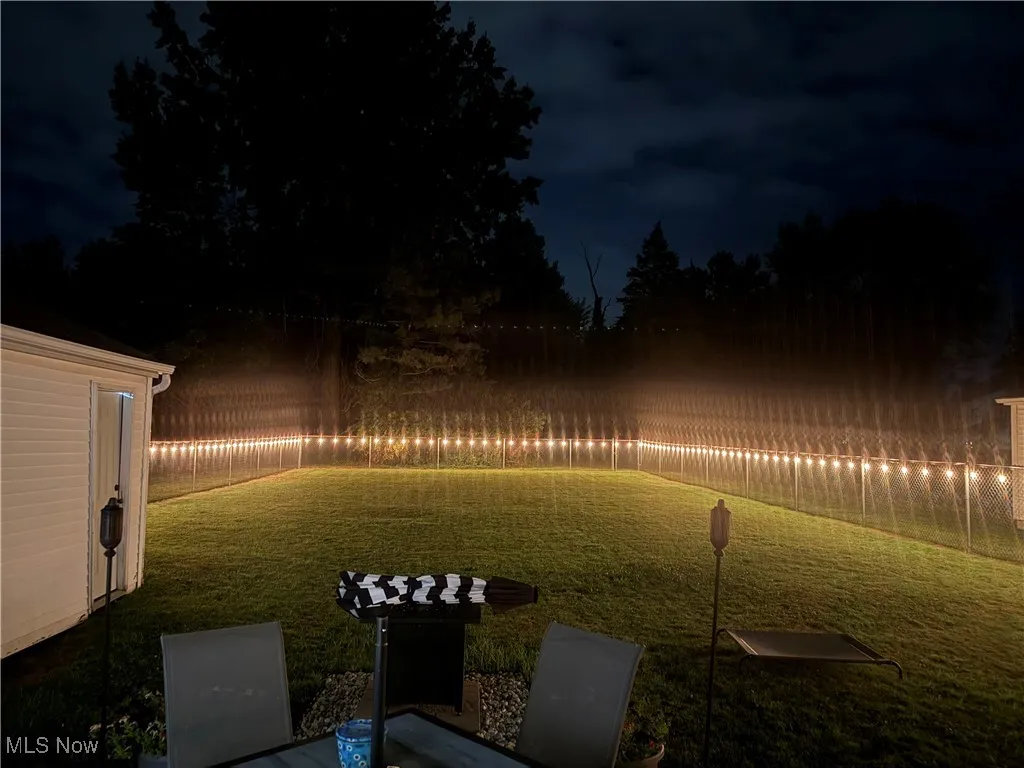 Yard at night featuring a fenced backyard