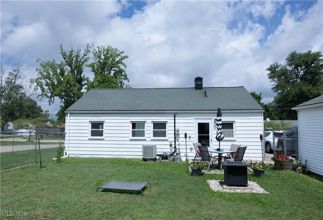 Rear view of property with a chimney and a shingled roof