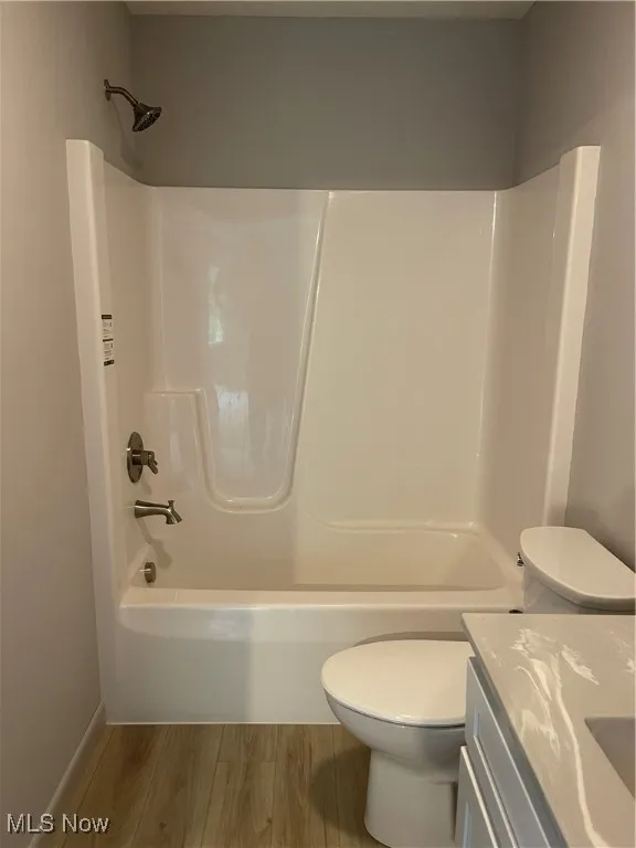 Full bathroom with wood finished floors, shower / washtub combination, and vanity