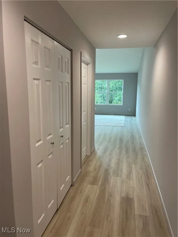 Hallway off of Entry Way with light wood finished floors and recessed lighting