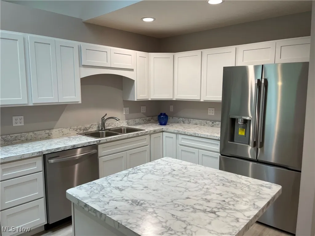 Kitchen featuring stainless steel appliances, white cabinets, recessed lighting, and a kitchen island