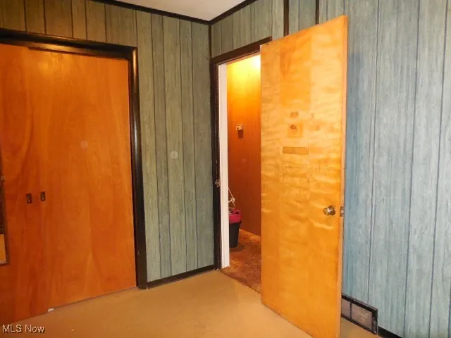 Spare room featuring wooden walls