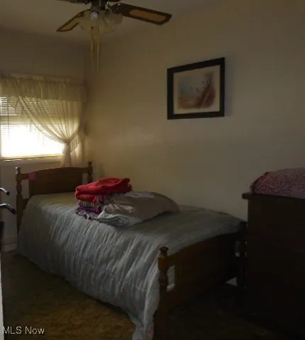 Carpeted bedroom featuring ceiling fan