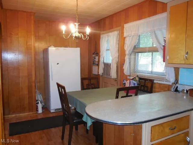 Dining space featuring a chandelier, wood finished floors, and wood walls
