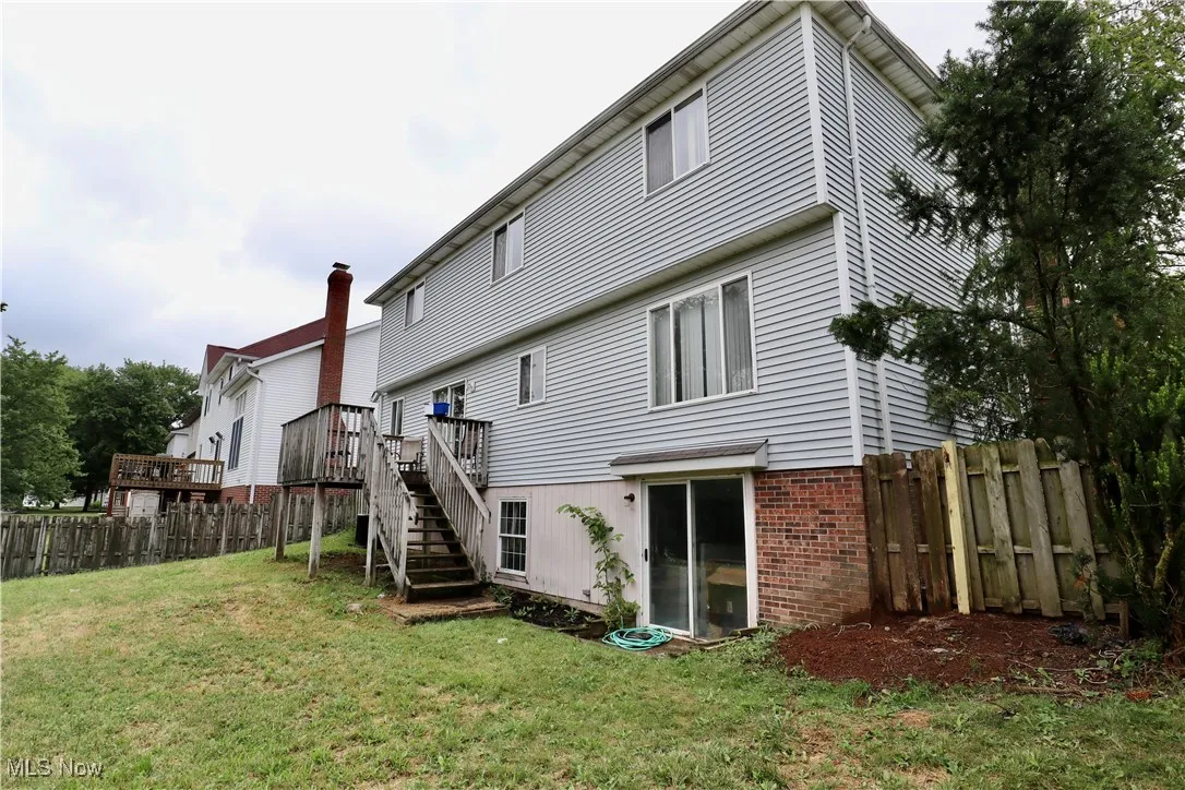 Back of property featuring brick siding, a deck, and stairway
