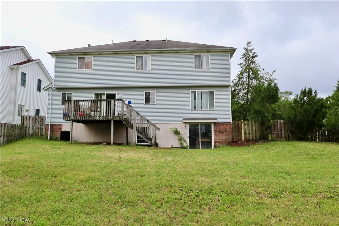 Rear view of house featuring stairway and a deck