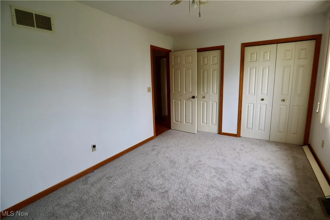 Unfurnished bedroom featuring two closets and carpet floors