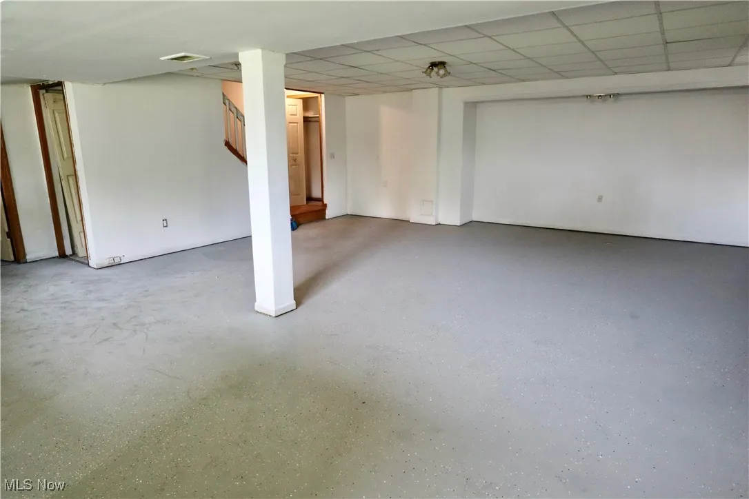 Finished below grade area featuring stairway and a paneled ceiling