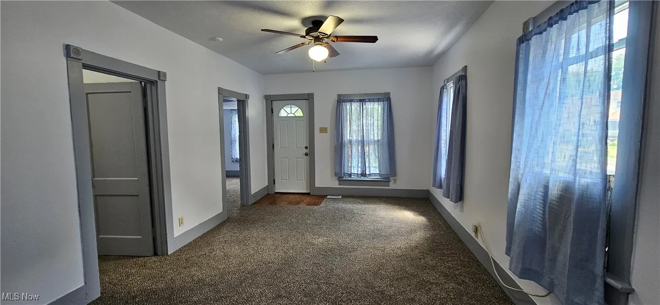 Living room featuring carpet flooring and ceiling fan
