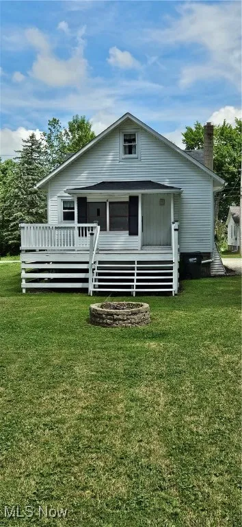 View of rear facade featuring a back yard, and large deck