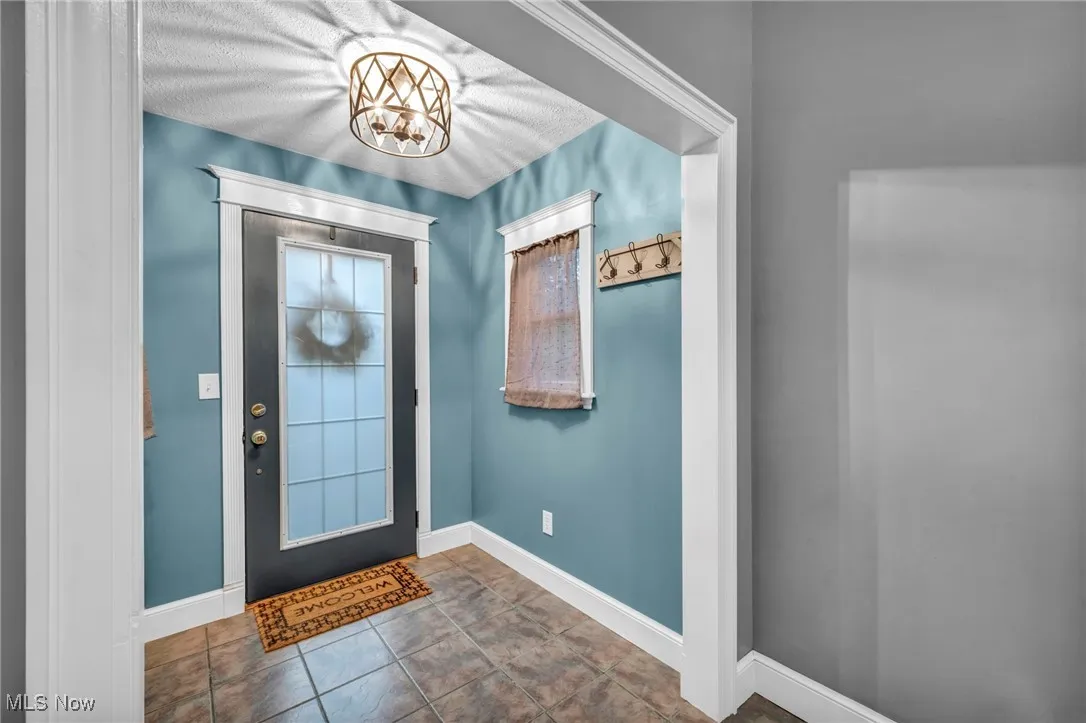 Entrance foyer with a chandelier and tile patterned flooring