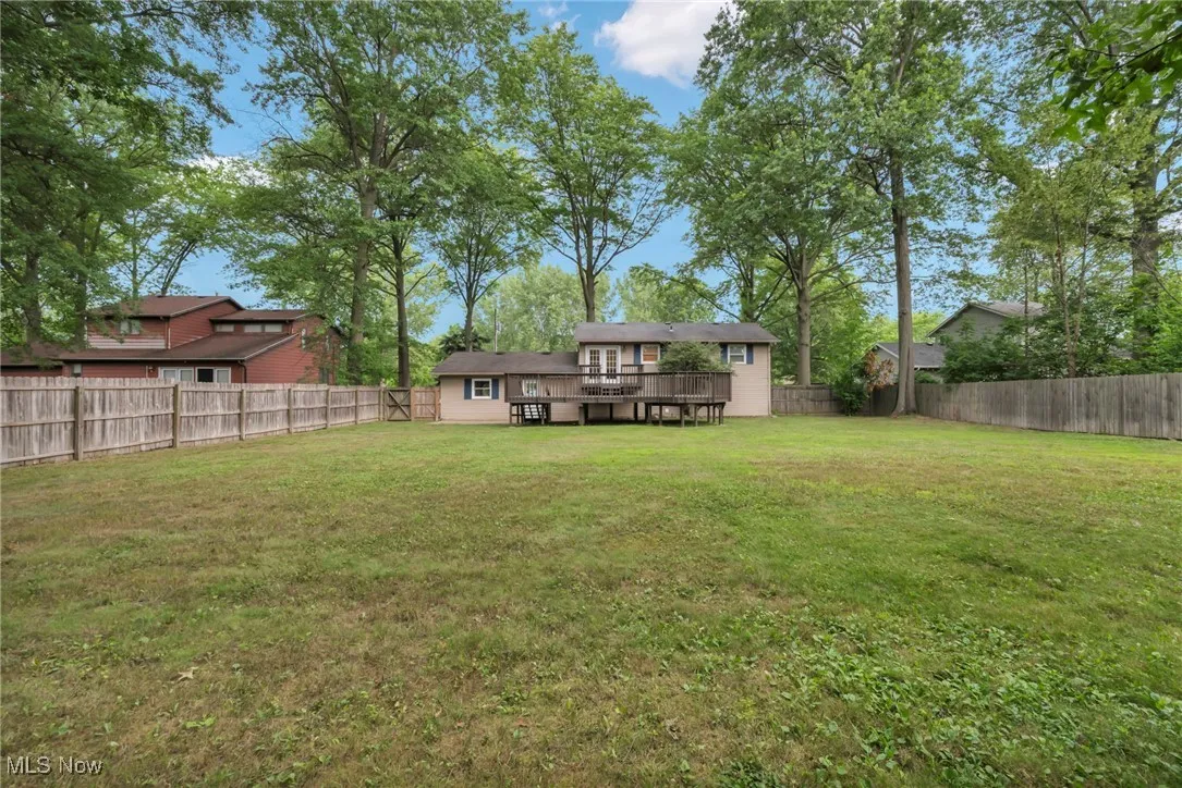 Fenced backyard featuring a deck