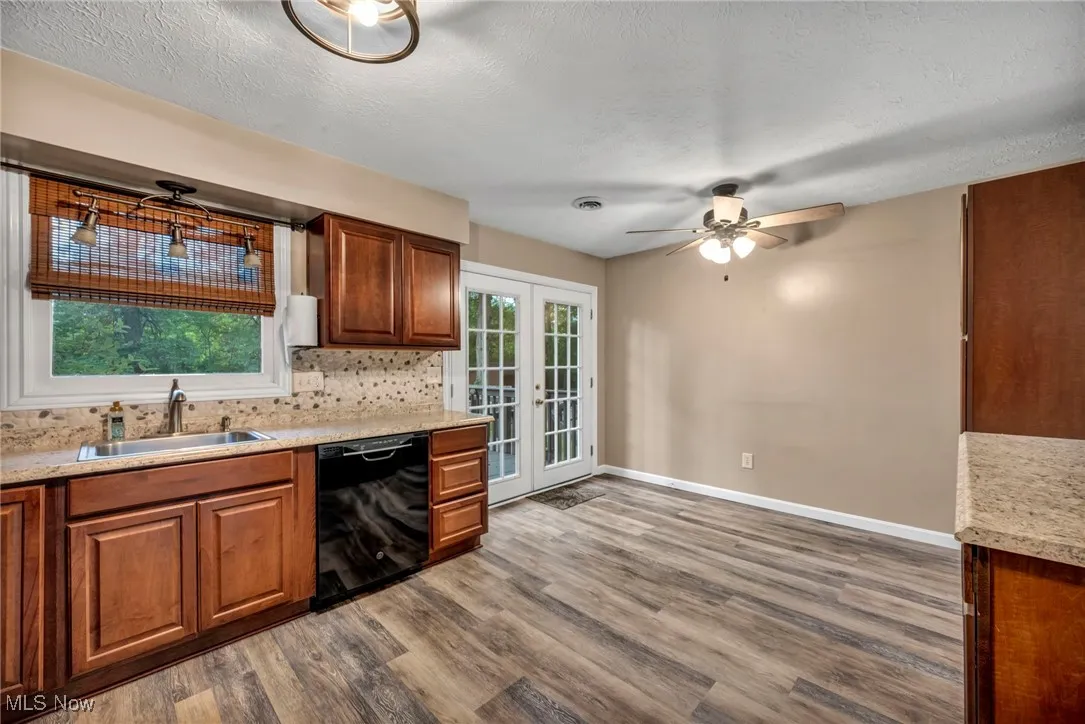 Kitchen featuring backsplash, dark wood-style floors, a textured ceiling, dishwasher, and ceiling fan