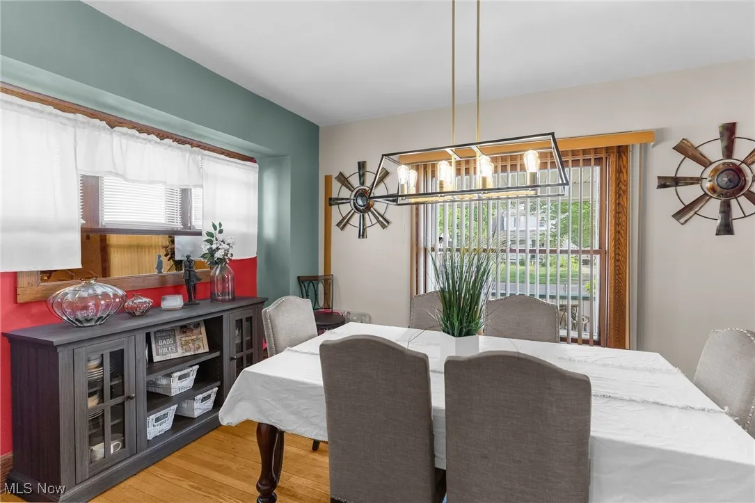 Dining room with wood finished floors and a chandelier