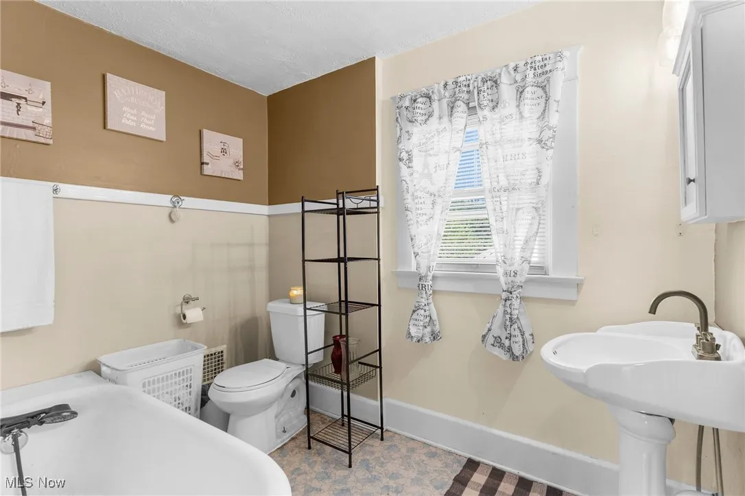 Bathroom with toilet and a tub to relax in