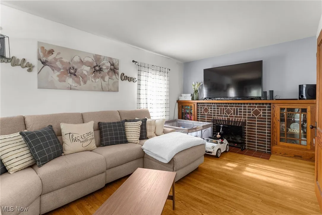 Living room featuring wood finished floors and a tiled fireplace