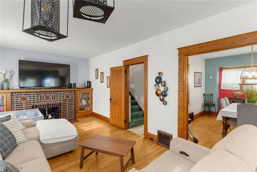 Living area featuring wood finished floors, stairway, and a tiled fireplace